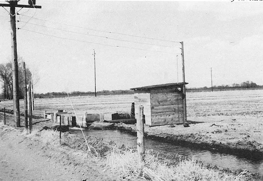 Irrigation well pump house with wooden headgates