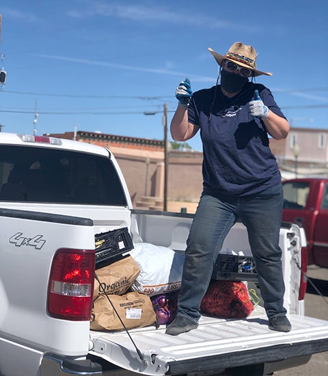La Puente employee standing in truck with thumbs up