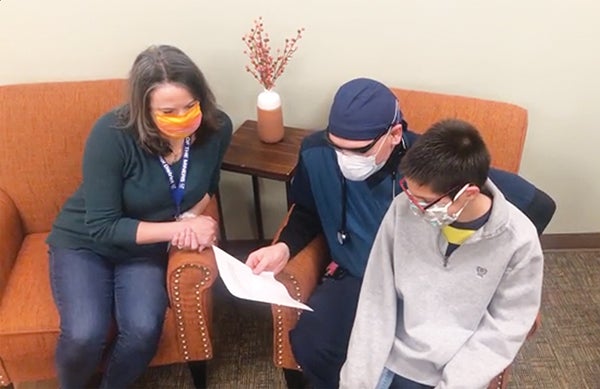 Family reading letter with face masks on