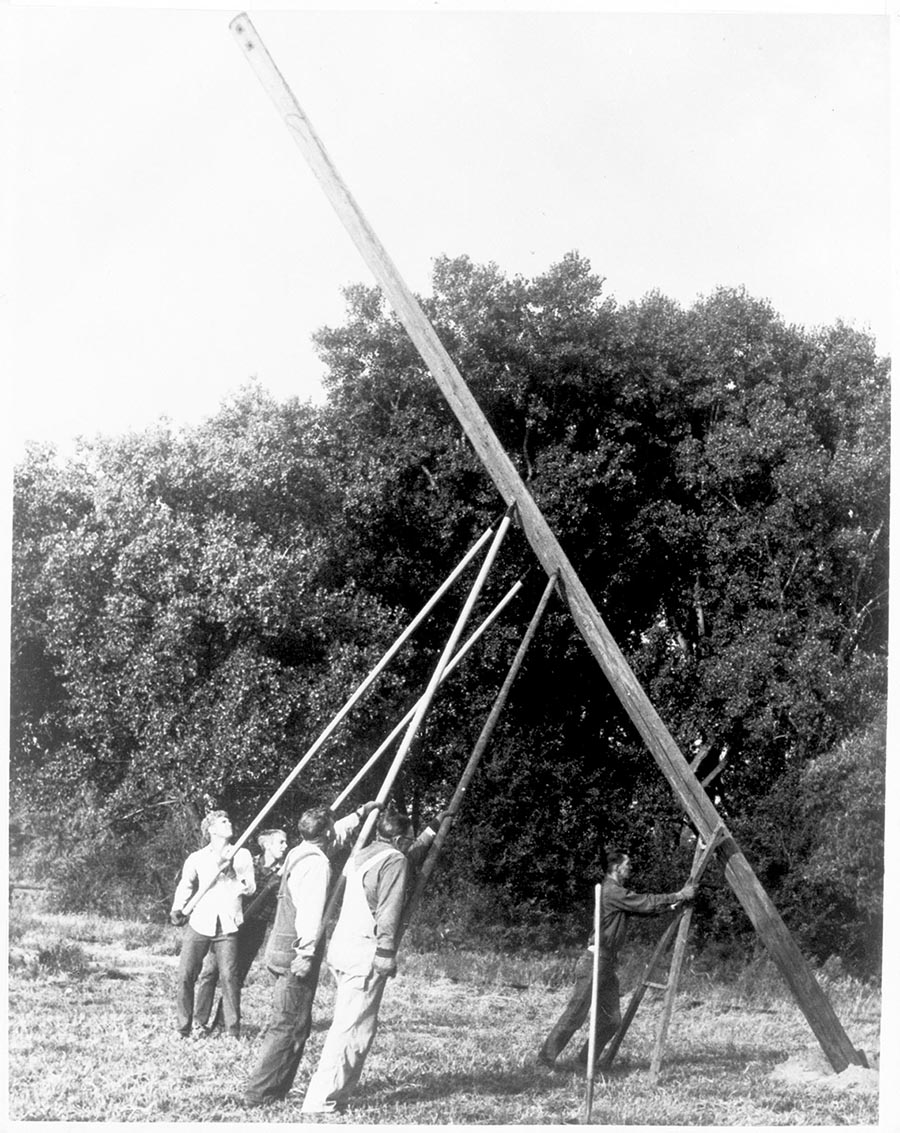 Men hoisting electric pole